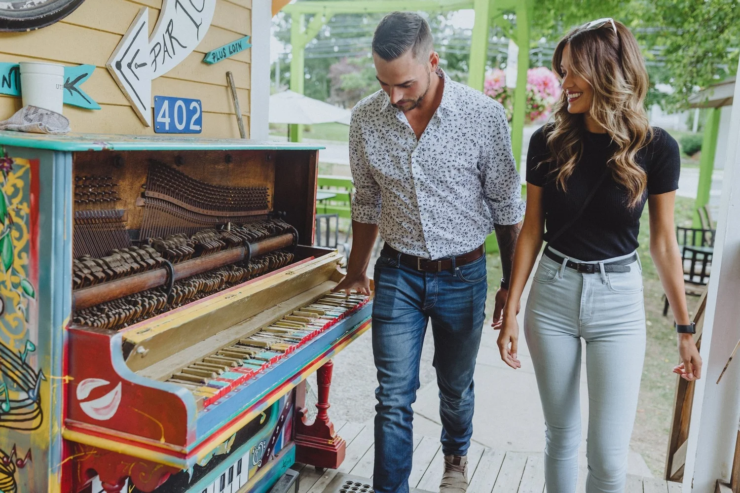 A couple at a painted upright piano on the patio