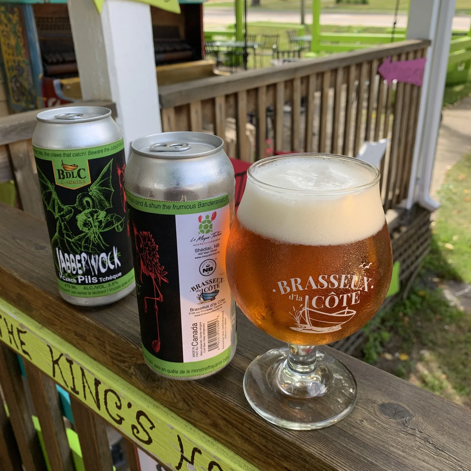 Craft beer can and glass on a chartreuse patio rail