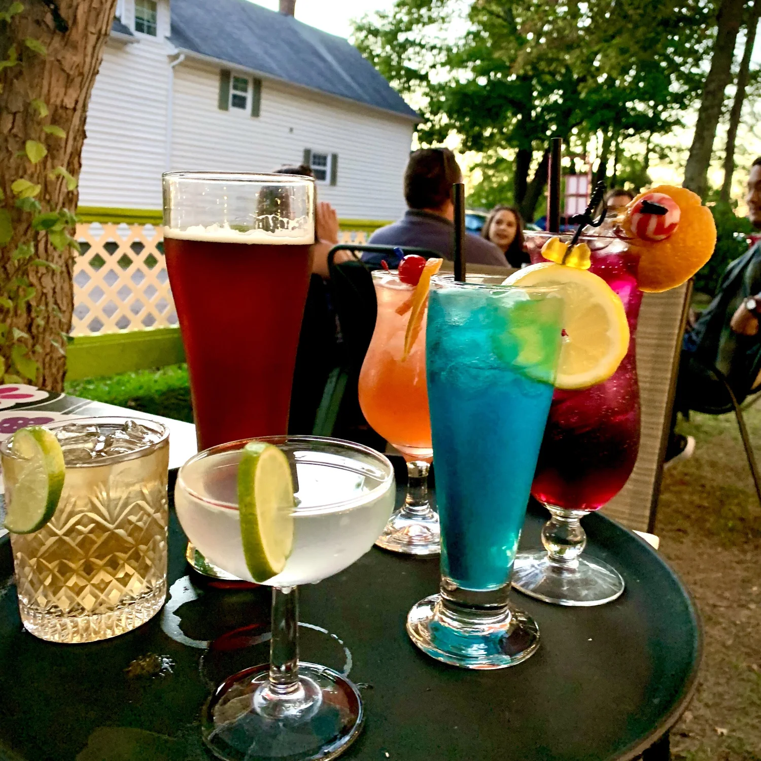 Row of colourful cocktails on the patio