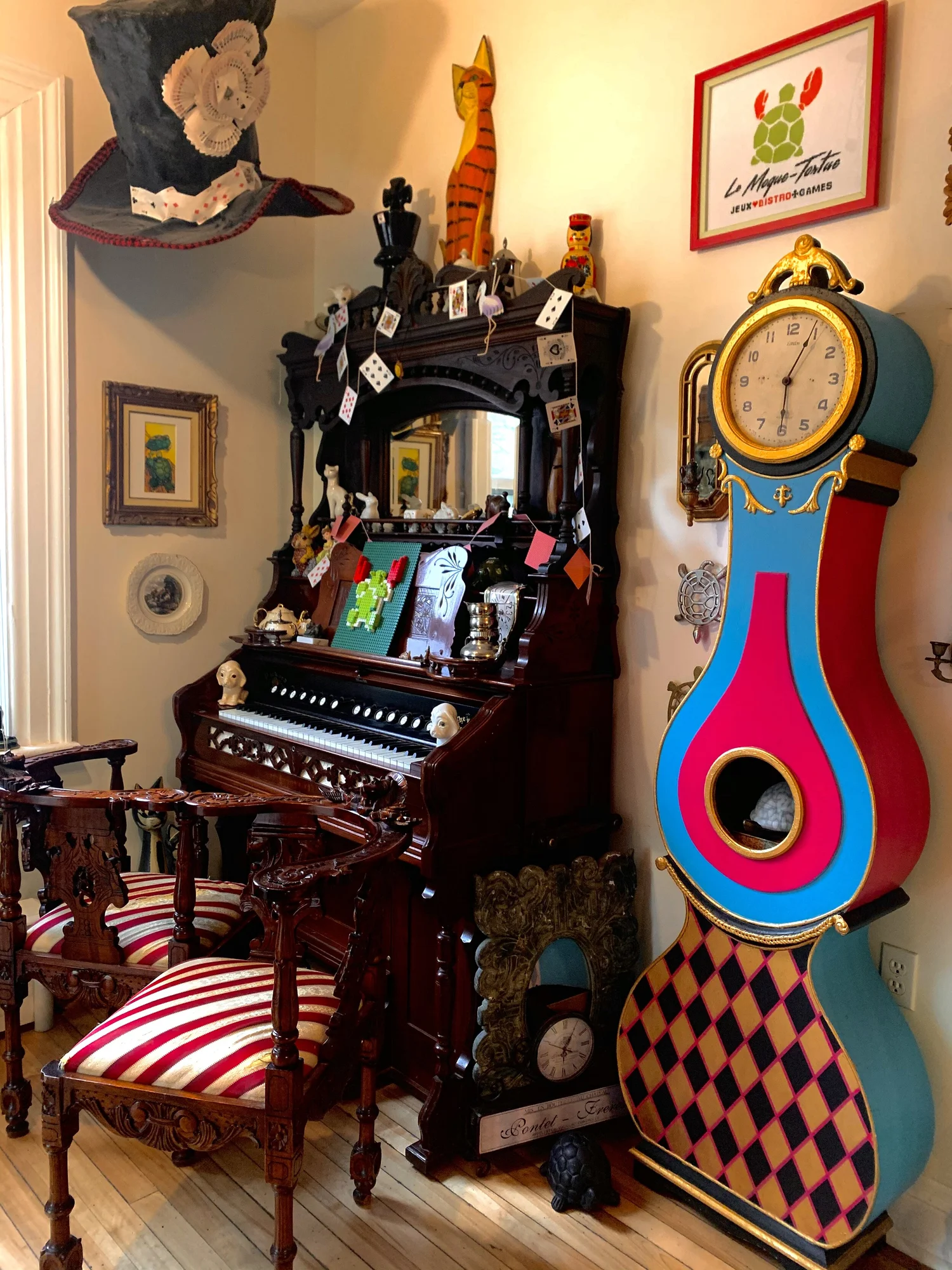 Alice in Wonderland details in the bistro interior — top hat, Mora clock, antique organ