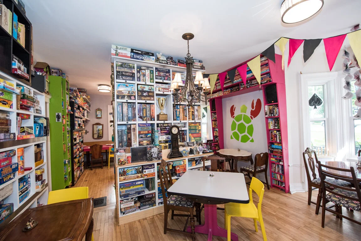 Bookshelves packed with board games, hot-pink tables, bunting and a painted turtle on the wall